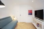 Snug with smart TV and sofa bed leading to utility room