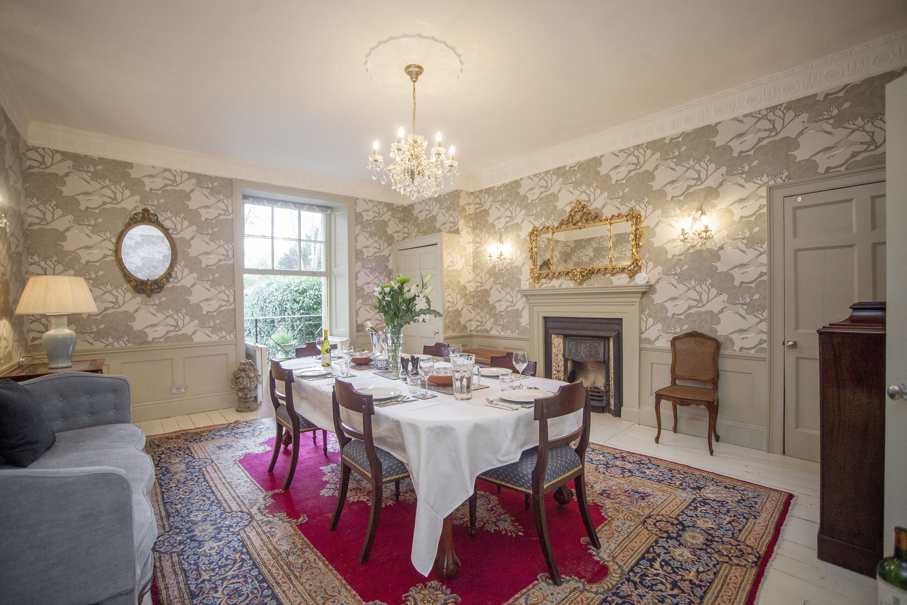 Dining room with sash window leading to wrought iron balcony and steps to courtyard