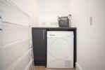 Utility room with washing machine and separate dryer at the back of snug