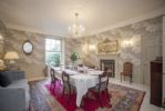 Dining room with sash window leading to wrought iron balcony and steps to courtyard