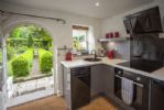 Sleek fully equipped kitchen leading to the garden